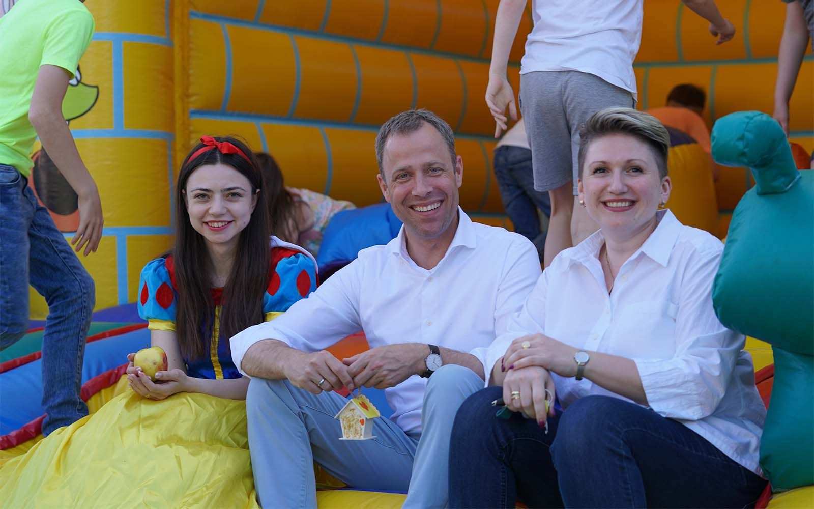 Bild vom Kindertag 2023 am Bürgerbüro in Marzahn-Mitte. Olga Gauks und Mario Czaja mit Schneewittchen auf der Hüpfburg.